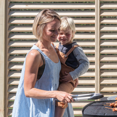 Woman barbecuing in front of trellis