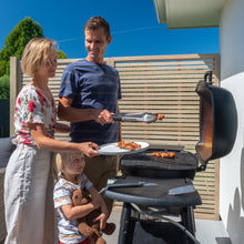 Load image into Gallery viewer, Family barbecuing in front of trellis